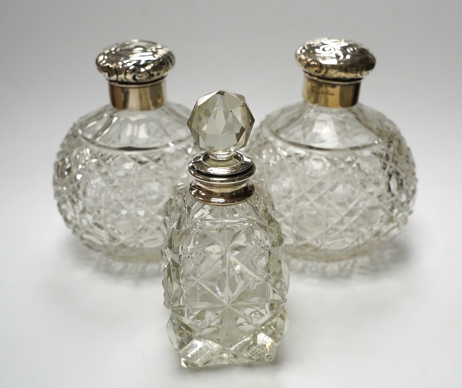 A pair of silver mounted cut glass scent bottles, marks rubbed, 12.3cm and one other silver mounted scent bottle. Condition - poor